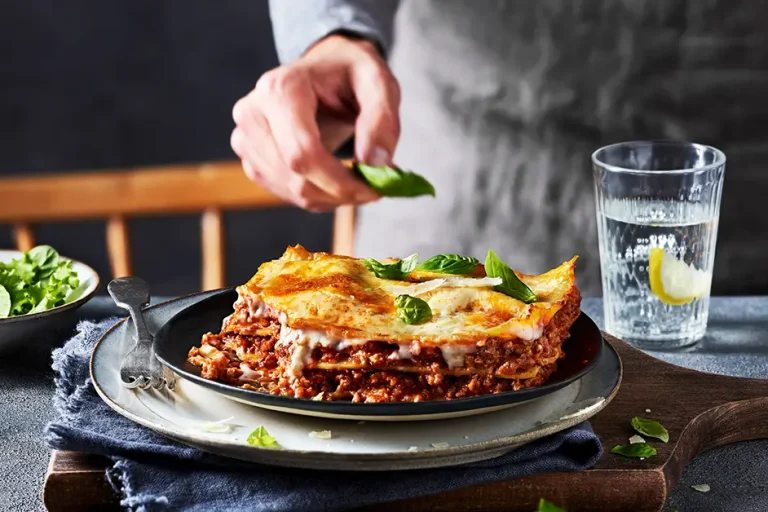 Photo of a chef decorating a lasagna dish 