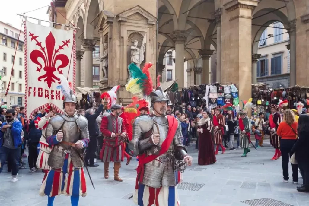 Cortejo histórico com trajes medievais e bandeira de Florença durante o Capodanno Fiorentino, na primavera