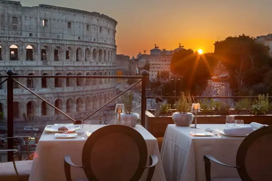 Jantar ao ar livre no restaurante Aroma, em Roma, com vista privilegiada para o Coliseu ao pôr do sol.