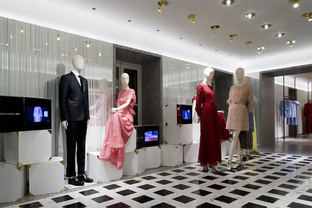 Vitrine da Valentino exibindo vestidos de alta-costura em um ambiente sofisticado, celebrando o luxo da Moda Italiana.
